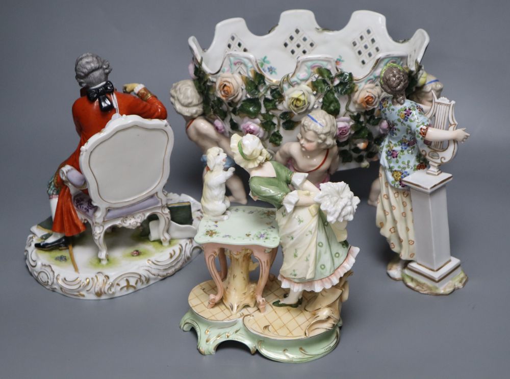 A Meissen style flower-encrusted reticulated oval porcelain jardiniere with cherub supports and three other items,